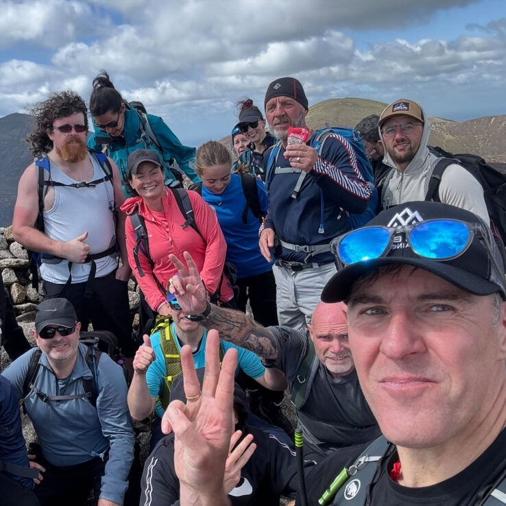 Exhausted but triumphant business team celebrating completion of four-peak mental wellness challenge