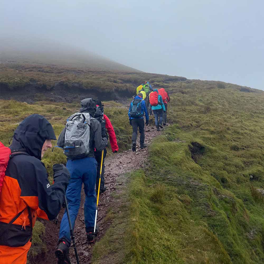 Mountain guide leading group safely down Irish peak with careful pace