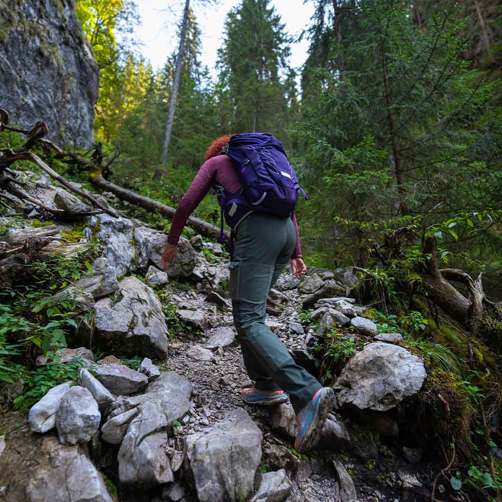 Solo hiker with backpack walking rolling Irish hills in overcast weather