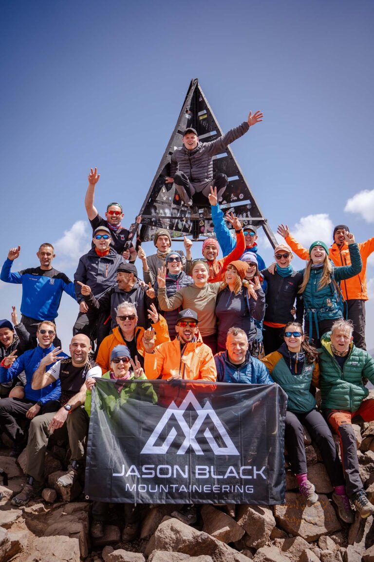 Trekkers ascending the south cirque scree slope toward the summit of Mount Toubkal Morocco.