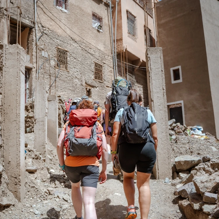 Women trekkers passing through Aremd Berber village in the High Atlas Mountains at 1,900m Morocco