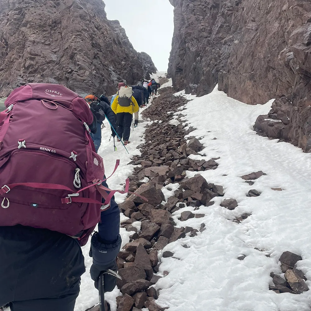 Mountaineer with crampons on snowy ridgeline High Atlas Morocco expedition