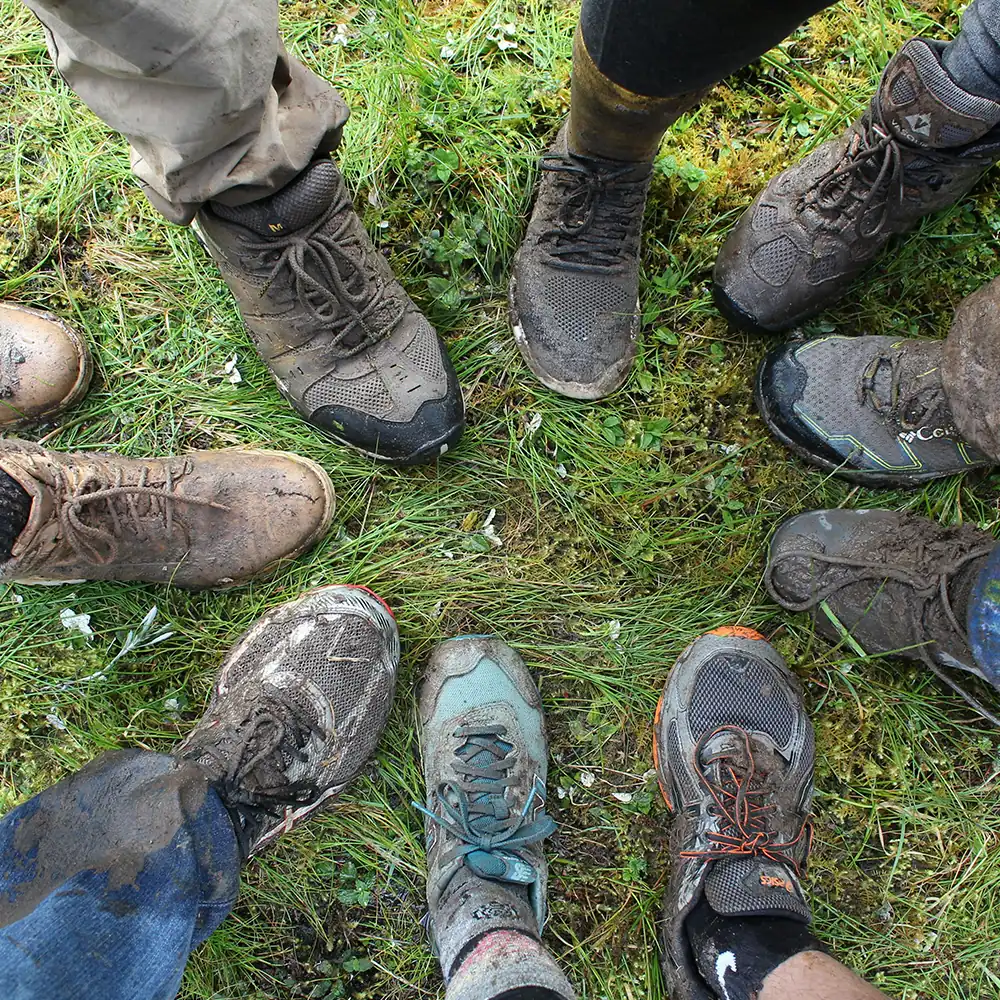Well worn trekking boots on mountain trail showing proper break-in for Kilimanjaro expedition preparation