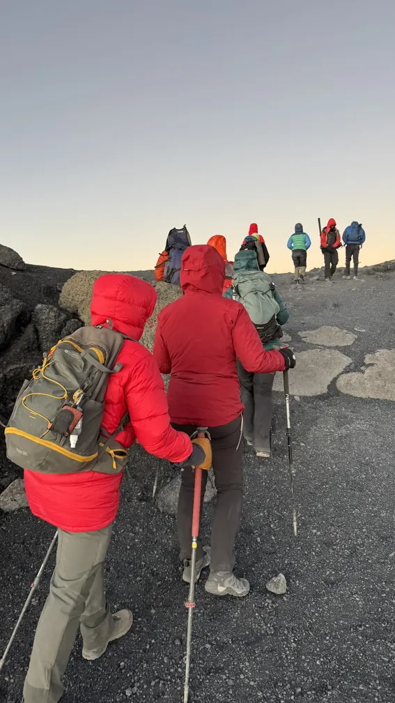 Mountaineer wearing complete high altitude layering system including down jacket and hardshell on Kilimanjaro Machame Route