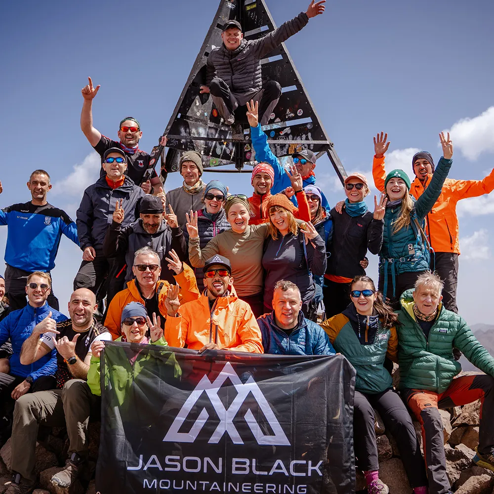 Mountaineers at the summit of Mount Toubkal 4167m with Irish flag High Atlas Morocco