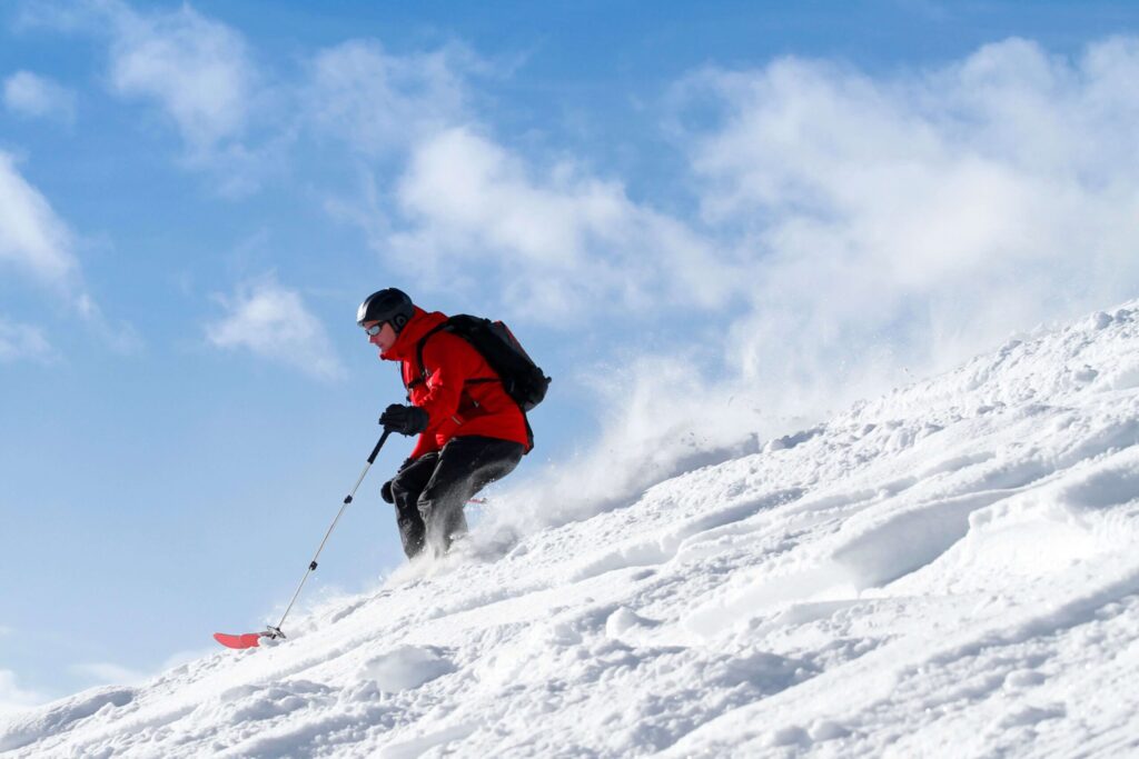 Backcountry skier moving laterally across a steep snow slope