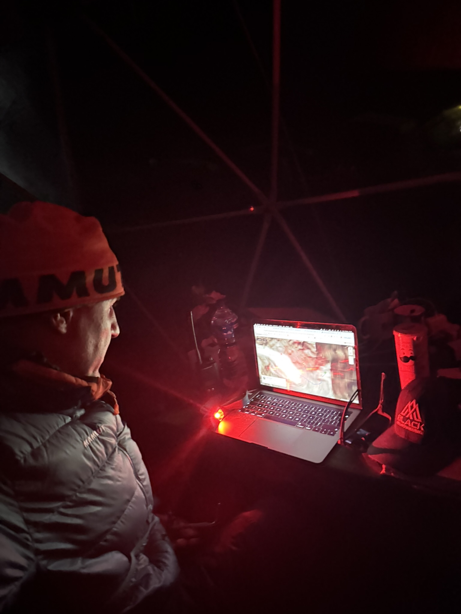 Mountaineer reviewing route and avalanche forecast on a snowy ridge